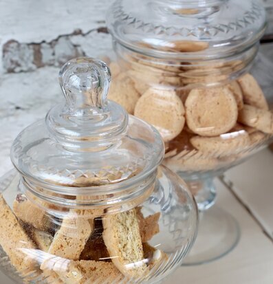 Foto av eleganta glaskrukor med kex på ljus yta