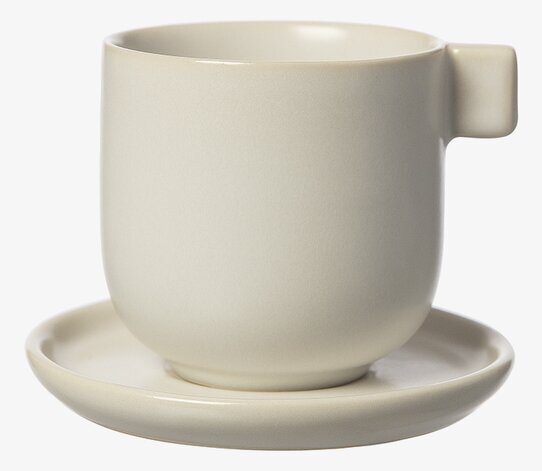 Bild av stilren kaffekopp med fat i vit sandfärg