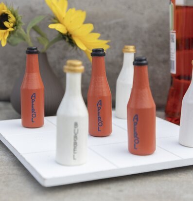 Bild av spelset med flaskpjäser och somrig bakgrund