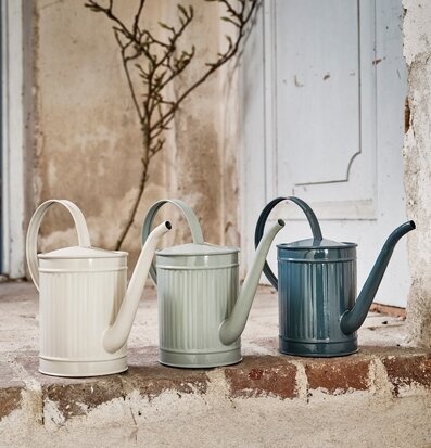 Bild av färgglada vattenkannor på rustik stentrappa