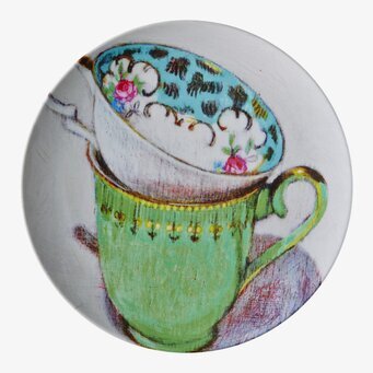 Bild av färgglad assiett med två dekorativa tekoppar