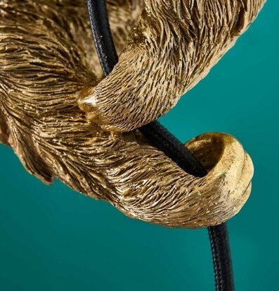 Bild av gyllene klo och mörk kabel mot turkos bakgrund