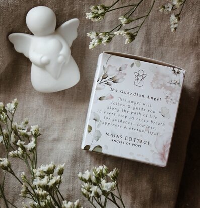 Bild av stilfullt arrangerad keramikängel och blommor