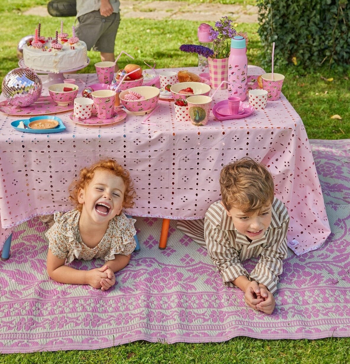 Plastmatta Rosa/Elfenbensvit från Rice på gräsmatta