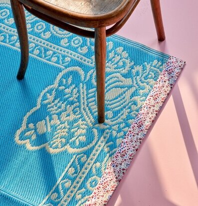 Bild av interiör med färgglad matta och trästol