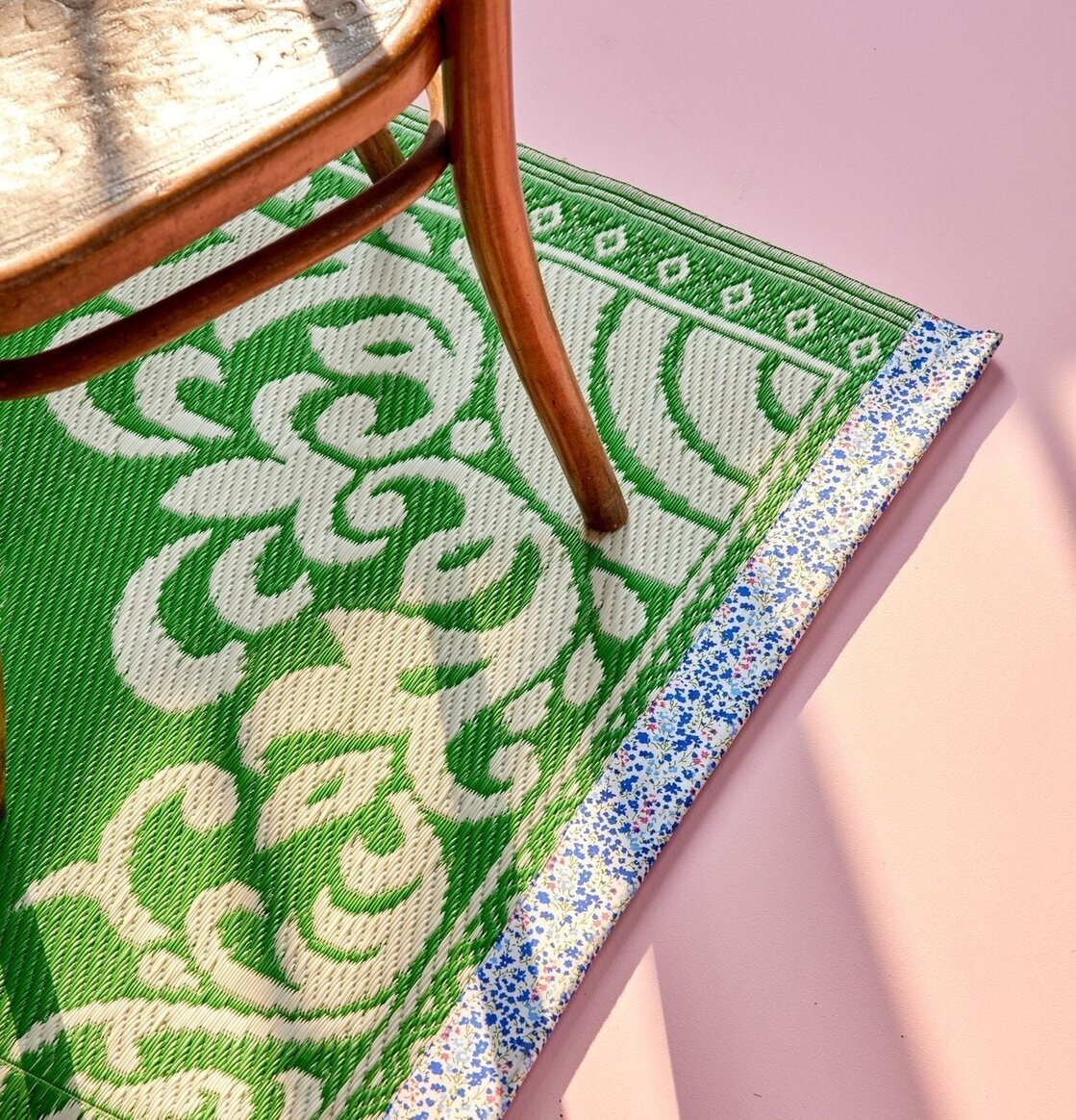 Bild av mönstrad plastmatta med trästol och skuggor