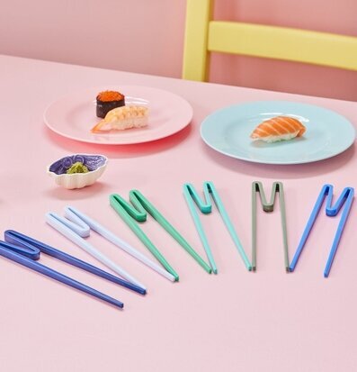 Bild av färgglada ätpinnar mot rosa bakgrund