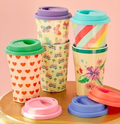 Bild av färgglada muggar med silikonlock på bord