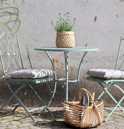 Foto av charmigt caféset mot rustik betongvägg