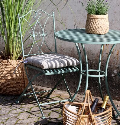 Foto av uteplats med antik grön caféstil och växter