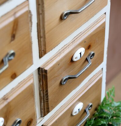 Bild av antik kommod med små lådor och etiketter