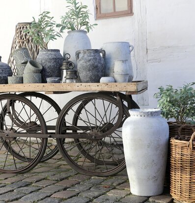 Foto av rustik vagn med krukor och lyktor i trädgård