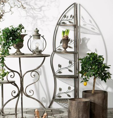 Foto av grön hörnhylla med växter och metall detaljer