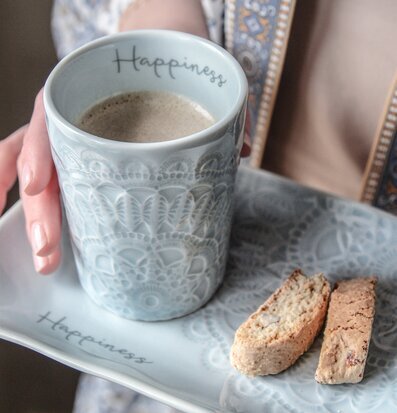 Bild av mugg och fat med marint tema och biscotti