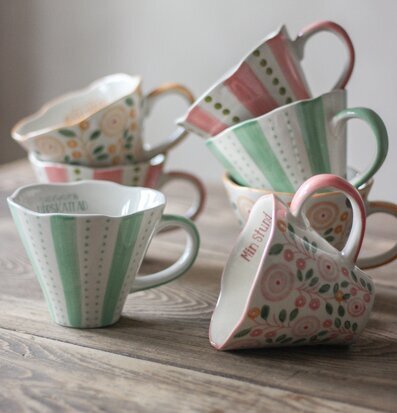 Bild av charmiga, handgjorda muggar med mjuka färger