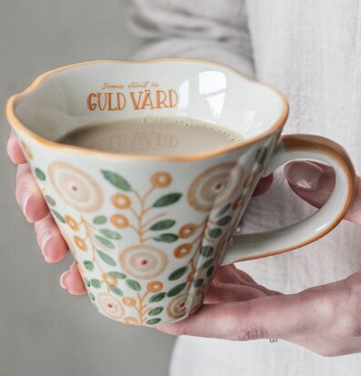 Bild av mugg med text och naturinspirerat mönster