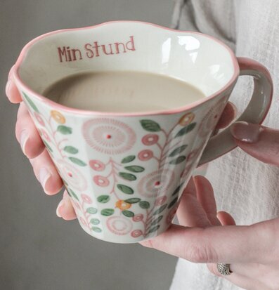 Foto av keramisk mugg med blommigt pastellmönster