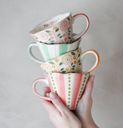 Bild av vackra staplade muggar mot ljusgrå bakgrund