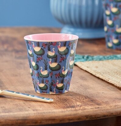 Bild av färgglad mugg med svanmönster i hemtrevlig miljö