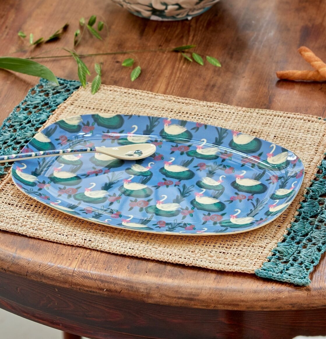 Tallrik Swan Lake Print från Rice på träbord med underlägg