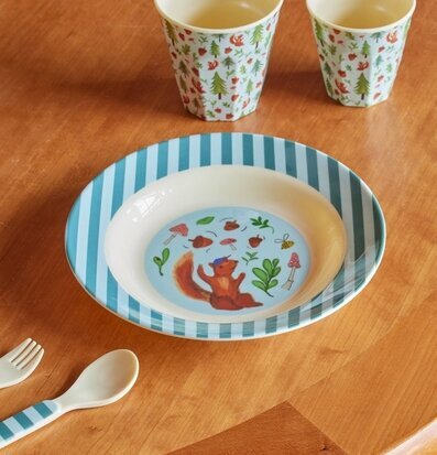 Bild av färgglad servis med skogstema på träbord