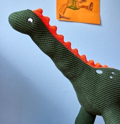 Bild av charmig prydnadskudde formad som dinosaurie