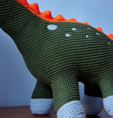 Bild av en prydnadskudde formad som dinosaurie