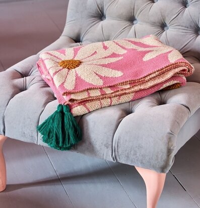 Bild av elegant fåtölj och färgglad filt i interiör