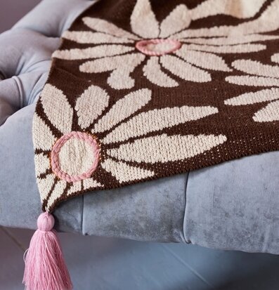 Bild av brun bomullsfilt med blommönster och tofsar
