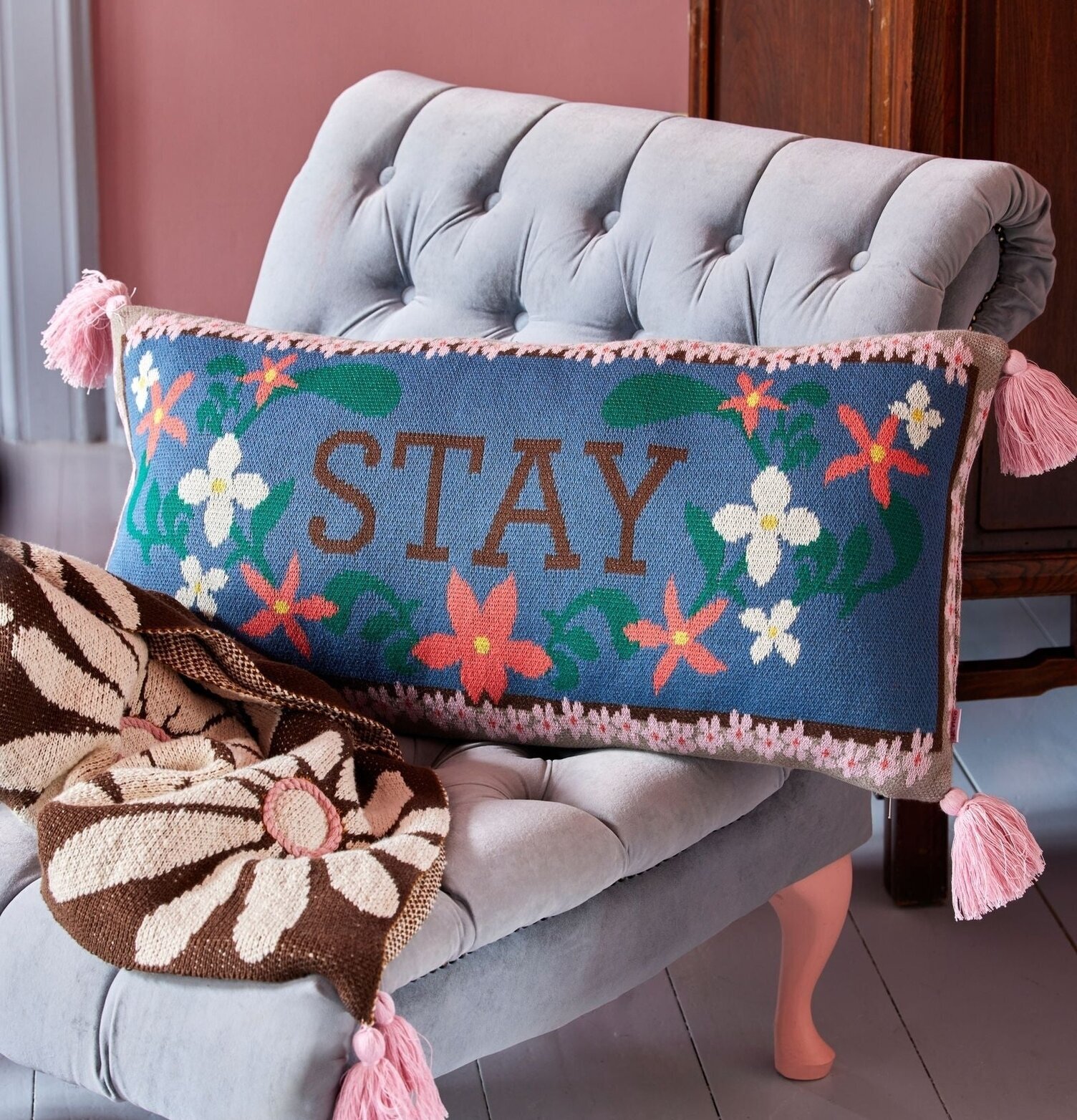 Prydnadskudde - Stay från Rice på ljusgrå stol med filt