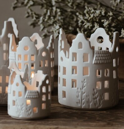 Bild av eleganta vita ljushus på rustikt träbord