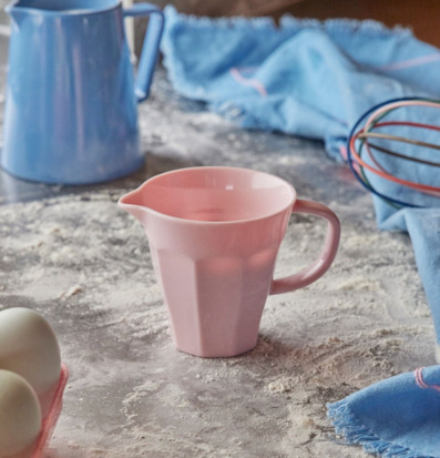 Bild av rosa mjölkkanna i ett aktivt kökslandskap