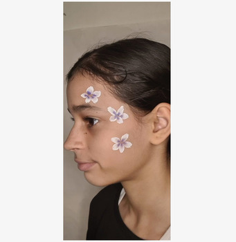 Bild av kreativ ansiktsmålning i lila och rosa toner