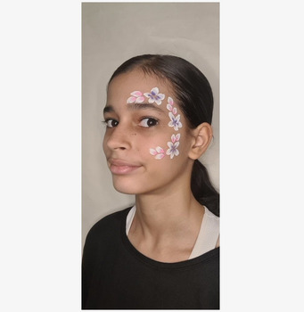 Bild på ansiktsmålning med blommönster i lila och rosa