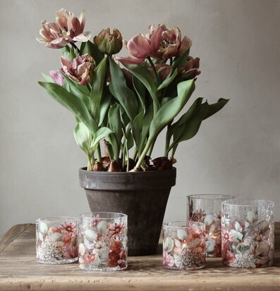 Foto av ljuslyktor på rustikt träbord med tulpaner