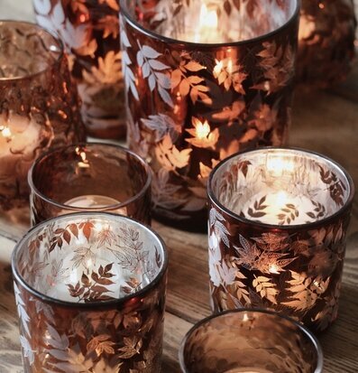 Bild av ljuslyktor med lövmönster och varm atmosfär