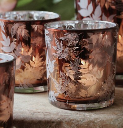 Bild av ljuslyktor med lövmönster i naturnära stil