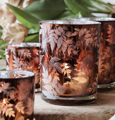 Bild av ljuslyktor med lövmönster och varm atmosfär