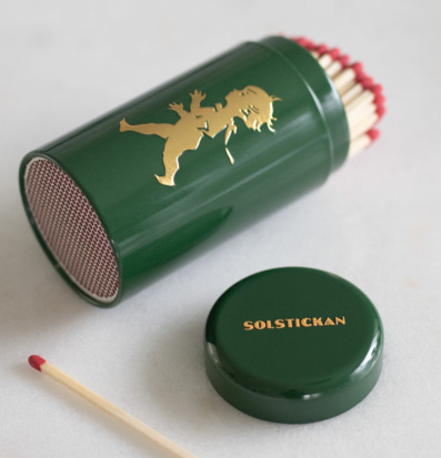 Bild av stilrent tändsticksrör i grön och guld design