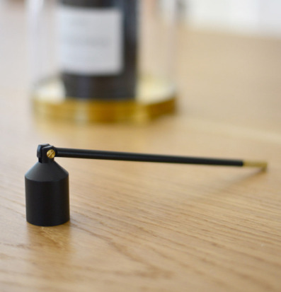 Foto av elegant ljussläckare på träyta med kontrast