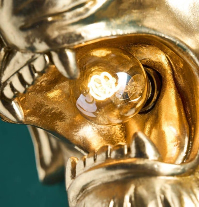 Bild av gyllene vägglampa med lejonhuvud och glödtråd