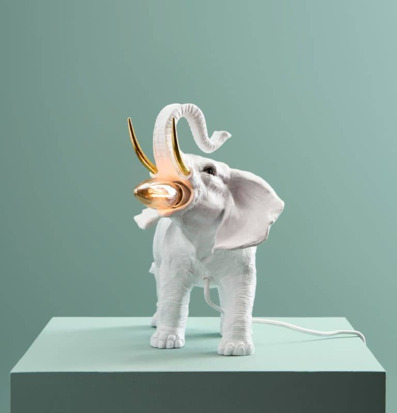 Bild av elegant vit och guld bordslampa i form av elefant