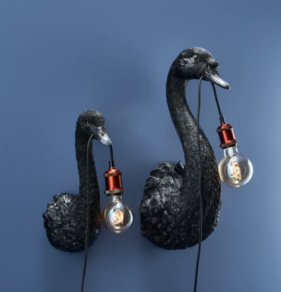 Bild av svarta svanformade vägglampor mot blå bakgrund
