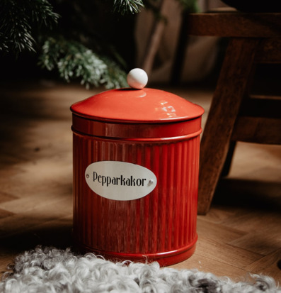 Bild av röd plåtburk för pepparkakor i hemtrevlig miljö