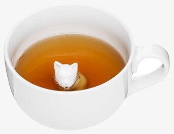 Bild av en vit mugg med lekfullt hundhuvud i botten