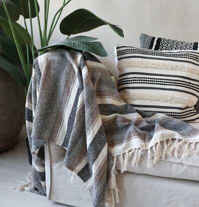 Bild av stämningsfull inredning med pläd och kudde