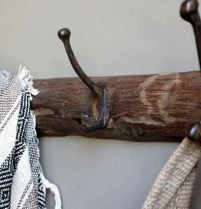 Bild av rustik klädhängare med textilier och krokar