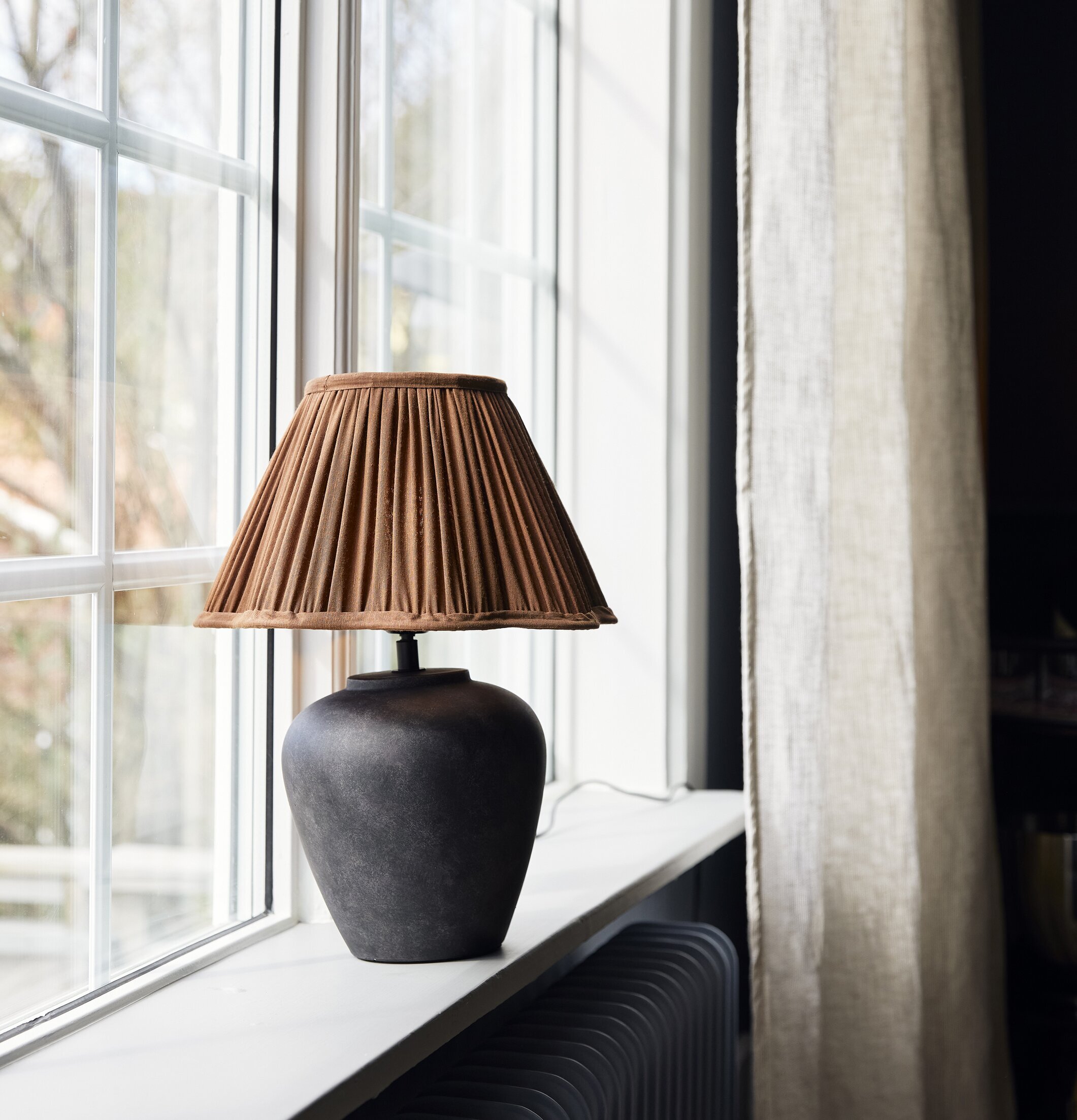 Foto av elegant lampa på fönsterbräda i hemtrevlig miljö