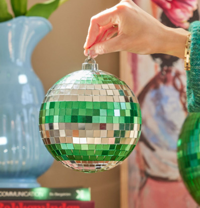 Bild av hand som håller glittrande discokula i rum