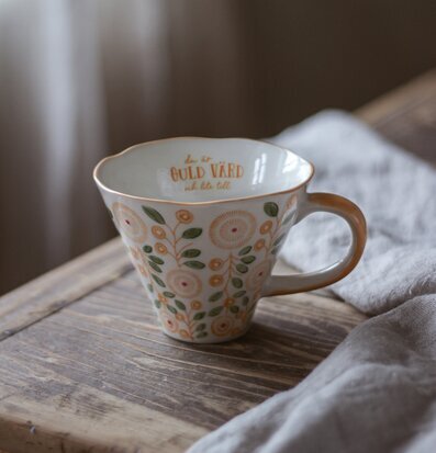 Foto av en charmig mugg med blommönster och text